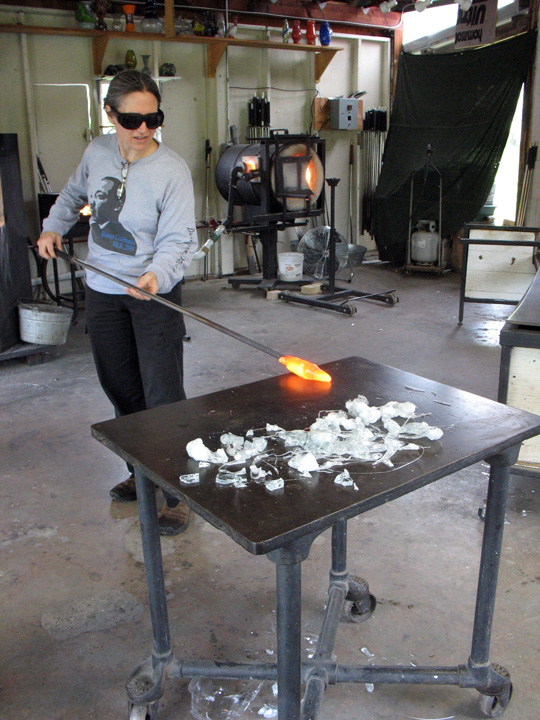 Marvering hot glass on a steel table.