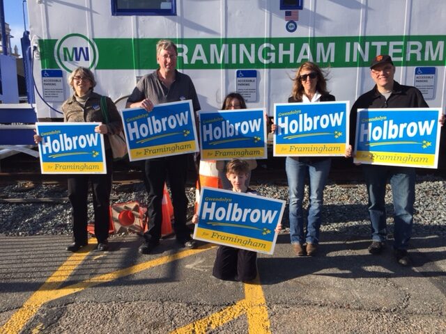 Six people holding election signs.